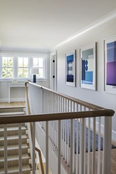 there are pictures on the wall next to the stairs in this house and it is very nice