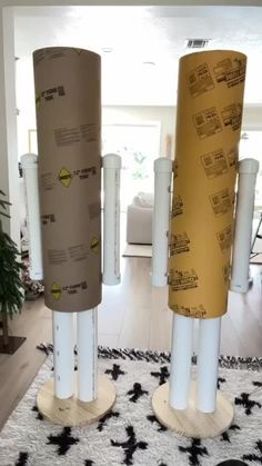 three tall cylindrical poles are standing in the middle of a living room with black and white carpet