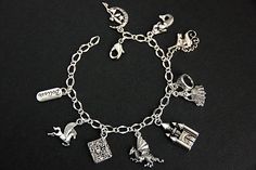 "A collection of silver plated fairy tale themed charms have been dispersed around a shimmering silver plated bracelet chain in this handmade charm bracelet. This fantasy storybook charm bracelet is then completed with a lobster clasp and a 1/2 inch of chain at the end for adjustable sizing. Charms in this bracelet include a \"Believe\" tab charm, pegasus charm, storybook charm, dragon charm, castle charm, princess charm with crown charm, unicorn charm, mermaid charm, and a fairy on the moon cha Adjustable Silver Jewelry For Fantasy Events, Collectible Themed Silver Jewelry, Themed Silver Collectible Jewelry, Adjustable Silver Fantasy Bracelet, Whimsical Silver Dangling Charms, Themed Silver Jewelry With Charms, Fantasy Style Silver Bracelet, Whimsical Silver Charm Bracelet, Whimsical Silver Bracelet Jewelry