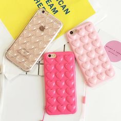 three cell phones sitting next to each other on top of a white table with earphones