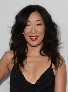 a woman in a black dress smiling at the camera