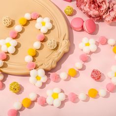 a pink and yellow cake with white frosting on it next to some candy candies