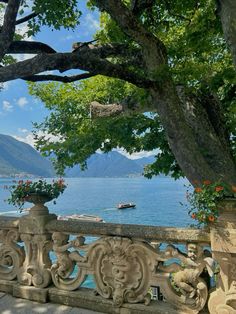 an ornate balcony overlooking the water with boats in the bay and trees on either side