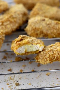 fried chicken on a baking rack with one piece taken out and the other half eaten