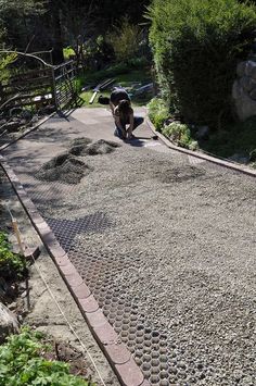 a man is working on the side of a road with rocks and gravel in front of him