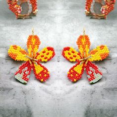 New from Narratives The Line. These eye-catching Small Orange & Yellow Ombre Flower Hook Earrings are the perfect way to add a touch of fun and whimsy to any look. Crafted with beaded ombre petals and featuring a delicate hook post, these earrings are the perfect pop of colour. Dimensions: approx. 3.5cm Diameter.  Surgical Steel posts. Designed in London, made by our friends in India. Summer Flower Beaded Earrings For Pierced Ears, Beaded Flower Earrings For Summer, Flower Shaped Earrings With Colorful Beads For Party, Colorful Beaded Flower Earrings For Party, Party Flower Earrings With Colorful Beads, Flower Shaped Earrings With Colorful Beads For Beach, Summer Multicolor Handmade Flower Earrings, Handmade Multicolor Flower Earrings, Multicolor Flower Shaped Beaded Earrings With Flower Charm