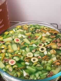 a pot filled with lots of vegetables sitting on top of a stove next to a can