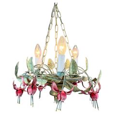 a chandelier with flowers and leaves hanging from it's center, against a white background