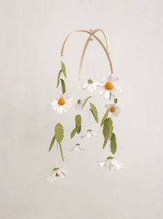 an image of a mobile with flowers hanging from it's sides on the wall