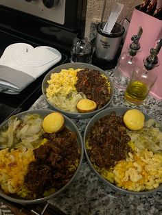 three bowls filled with food sitting on top of a counter next to a toaster oven