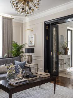 a living room with a couch, coffee table and chandelier