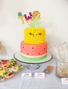 a cake with pineapple and watermelon on top is sitting on a table