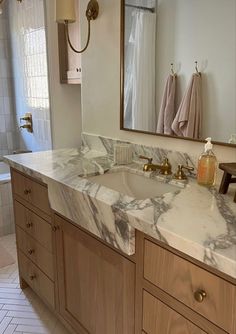 a bathroom with marble counter tops and wooden cabinets