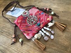 a pink purse with beads and charms on it sitting on top of a wooden table