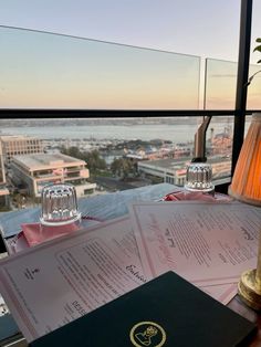 a table with some papers on it next to a lamp