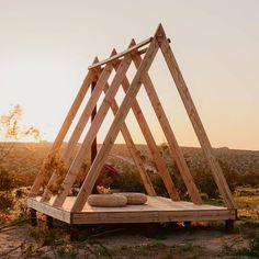 a wooden structure sitting in the middle of a field