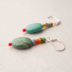 Leverback dangle earrings are composed of an assortment of turquoise stones and African trade beads.  Our earrings are handmade and one of a kind. SIZE 2" GIFTABLE A jewelry gift pouch is included. The pouch will differ from the one photographed. A representative sample is shown. READY TO SHIP Each piece is a handcrafted one-of-a-kind piece. Our pictures represent a close color palette of the glazed stoneware and semiprecious stones as well as the typical shape and size variations.  The item you receive will be very similar to the item photographed but will vary slightly in coloration and design. COORDINATING PIECES Pendant Necklace https://www.etsy.com/listing/1717145800/mosaic-necklace-in-gift-pouch-colorful?ref=listings_manager_table Ring https://www.etsy.com/listing/1702844048/adjustab Mosaic Necklace, Manager Table, Turquoise Belt, African Trade Beads, Mosaic Wall Art, Pottery Shop, Turquoise Stones, Trade Beads, Copper Chain