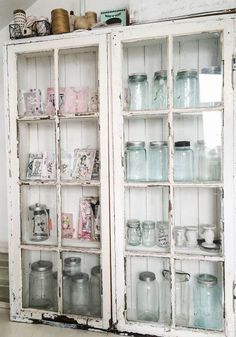 an old china cabinet with glass doors and jars