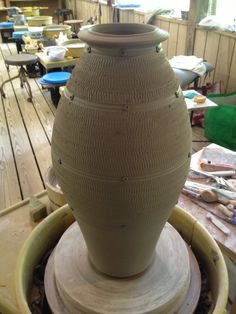 a large vase sitting on top of a wooden table