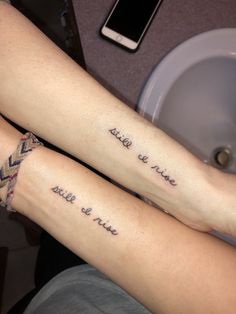 two people with matching tattoos on their legs, both have words written on the arms