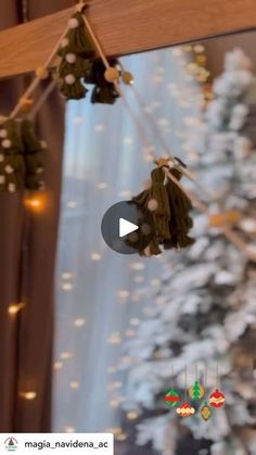 christmas decorations hanging from the ceiling in front of a window with lights and snow on it