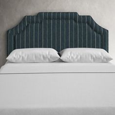 an upholstered headboard with two pillows on the top and bottom of it