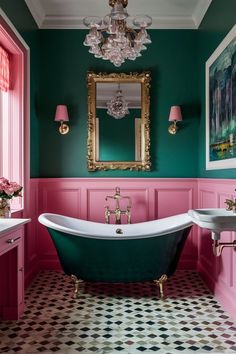 a bathroom with pink and green walls, an antique claw foot bathtub and chandelier