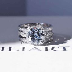 a diamond ring sitting on top of a white sheet with the word stuart written below it