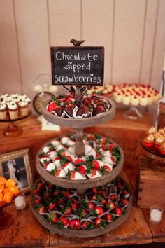 an assortment of cupcakes and desserts displayed on a table with a chalkboard sign