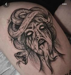 a woman's thigh with a snake and demon tattoo design on it, as well as an inscription