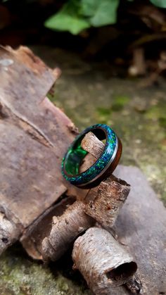 "Fumed Eucalyptus wood wrapped around a Dark Green epoxy core with an inlay of Crushed Dark Green opal and Silver wire. This ring is handmade from Fumed Eucalyptus wood with good weight and a comfortable fit. The ring is coated with acrylate, making for a waterproof and scratch resistant surface. Fumed Eucalyptus Wood Ring with Dark Green Opal and Silver Lining. Fumed Eucalyptus Bentwood Ring. Wrapped around a Green epoxy core featuring an inlay of crushed Dark Green Opal separated with a Sterli Bentwood Rings, Eucalyptus Wood, Wood Ring, Green Opal, Silver Lining, Wood Rings, Ring For Men, Wedding Jewelry Sets, Rings For Her