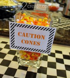 a glass filled with candy sitting on top of a checkered table