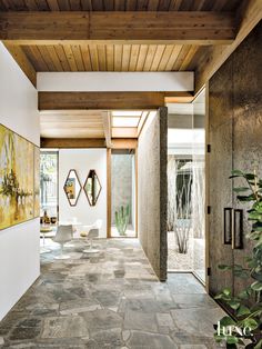 an entry way with artwork on the wall and stone flooring in front of it