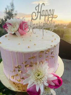 a pink and white cake with flowers on top