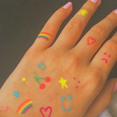 a person's hand with rainbow and stars painted on it