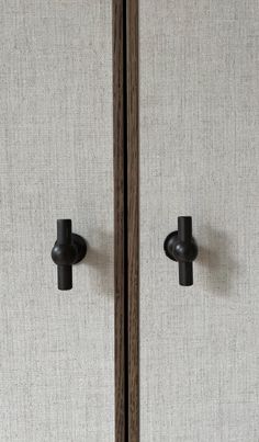 two wooden doors with black handles on them