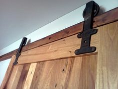 a close up of a wooden door with two black latches on the handlebars