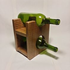 two green wine bottles in a wooden holder