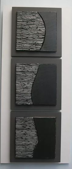 three black and white paintings hanging on a wall