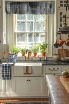 a kitchen filled with lots of pots and pans on top of a counter next to a window