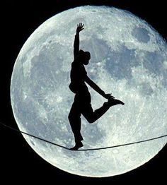 a man is balancing on a tightrope in front of the moon