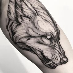 a black and white photo of a wolf's head on the right arm, done in ink