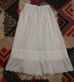 This is a charming antique Edwardian petticoat in excellent condition. It is white cotton and measures 28" in length. The waist is 22" and there is a 10" placket in the back with a snap and a pearl button at the waist. It is tightly shirred in the back and is and is nice and full. It has a lovely embroidered ruffle with a scalloped edge and there is a 1" pleat that I believe was to lengthen when needed. It is in excellent condition- clean (just washed and pressed) and has no spots or holes. I combine shipping and am happy to provide a shipping quote to international shoppers. Thanks for visiting... Victorian Cotton Petticoat For Daywear, Victorian White Ruffled Petticoat, Victorian White Petticoat With Ruffles, Fitted Cotton Petticoat With Ruffles, Vintage Fitted Petticoat For Daywear, Spring Cotton Petticoat With Lace Trim, White Fitted Cotton Petticoat, Fitted White Cotton Petticoat, White Regency Style Petticoat With Ruffles