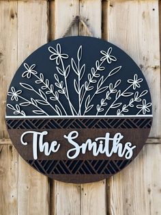 a wooden sign that says the smiths on it's side hanging on a fence