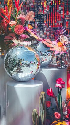 there is a disco ball on top of a table with flowers in it and other decorations