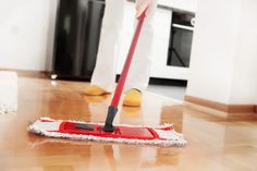 a person using a mop to clean the floor