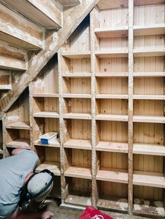 a man is working on some shelves in a room that has been built into the wall