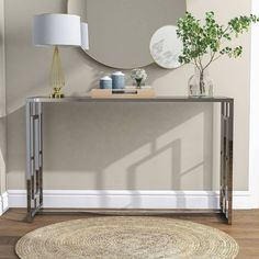 a modern console table with a round mirror on the wall above it and a rug underneath