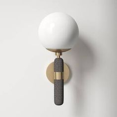 a white ball mounted on a wall with a black and gold handle next to it