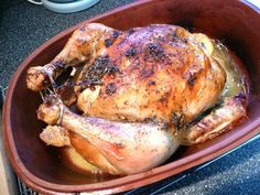 a roasted chicken in a bowl on the stove